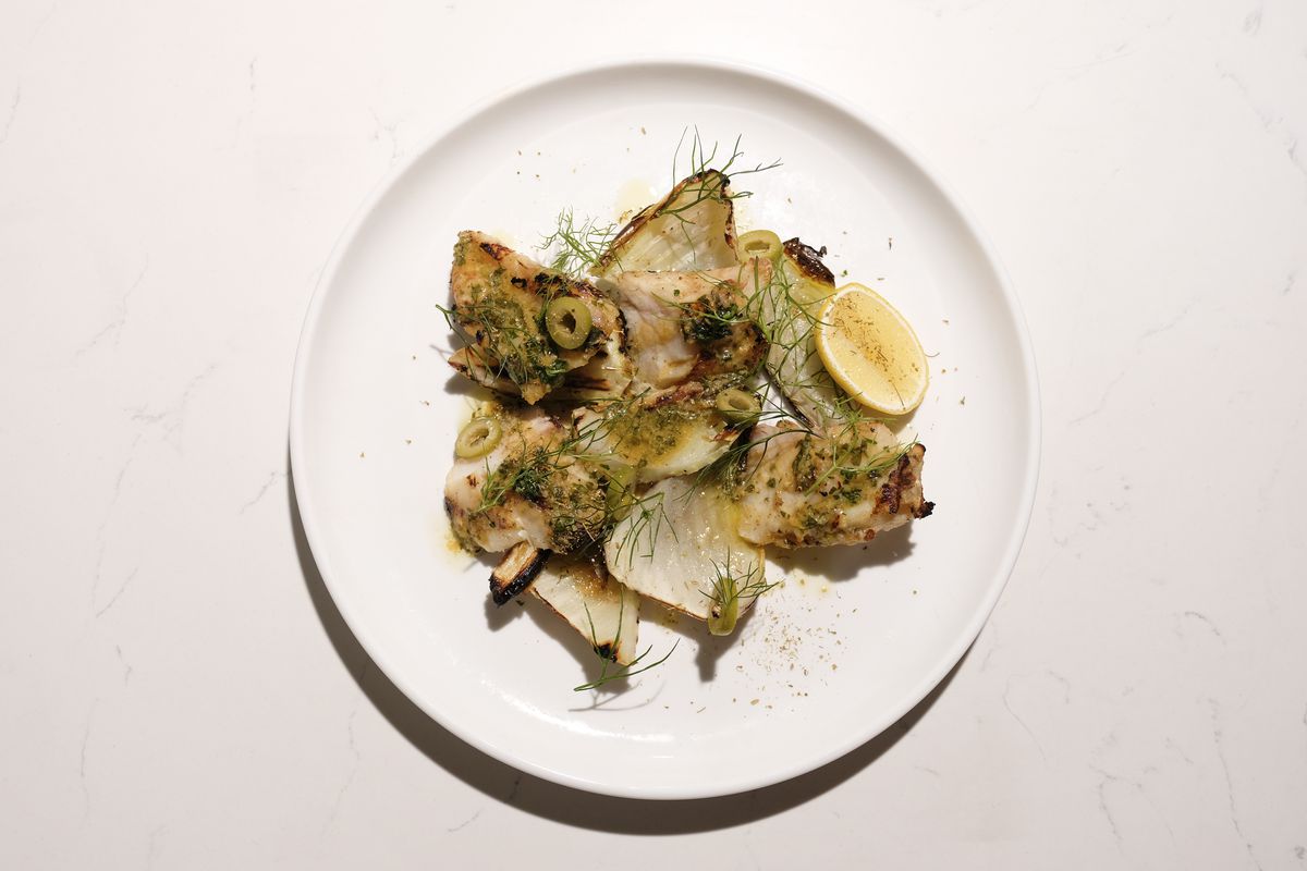 Pescado a la plancha en un plato blanco con hinojo
