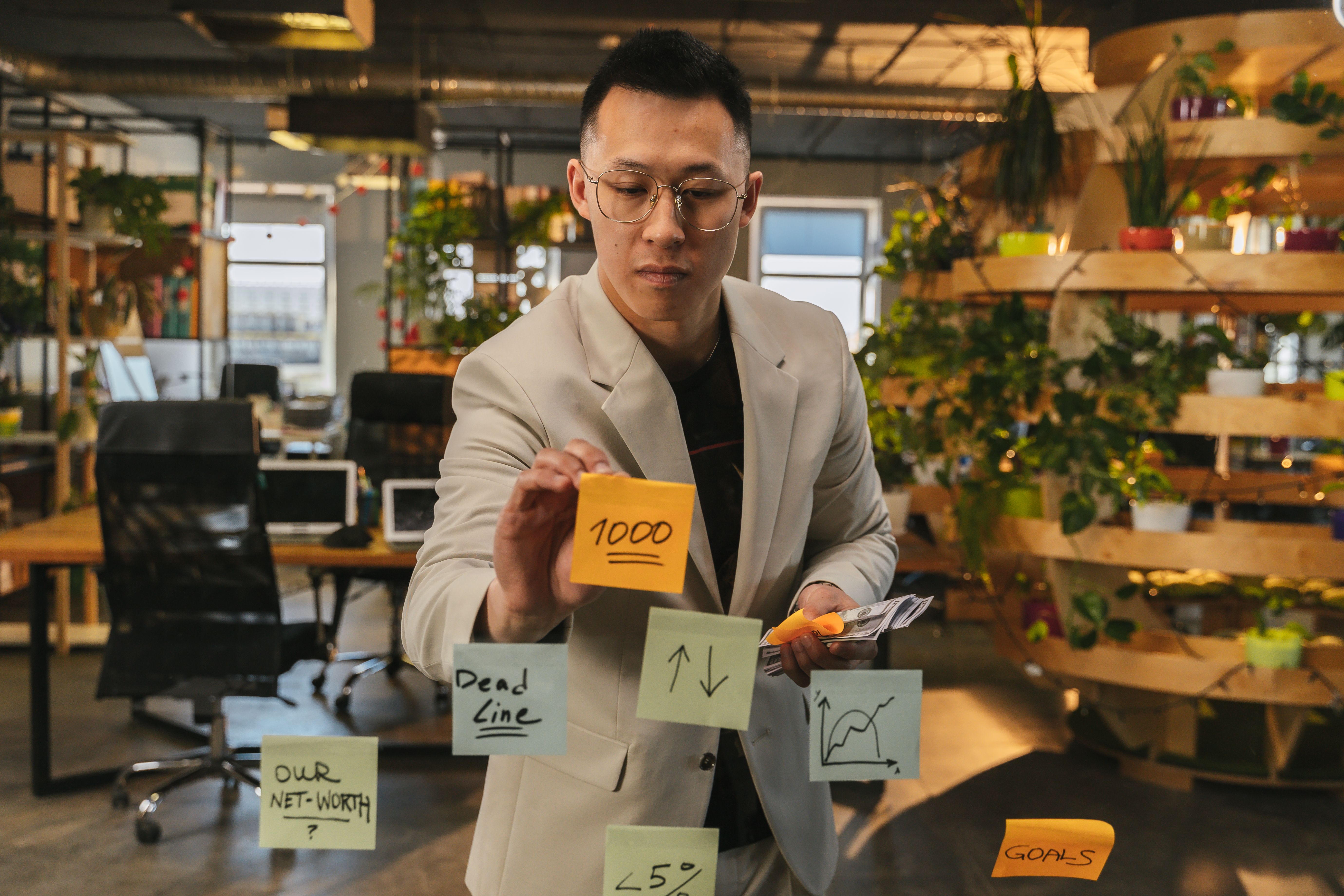 Businessman using sticky notes for strategic planning in a green office