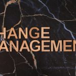 Wooden letters spelling 'Change Management' on a dark marble surface