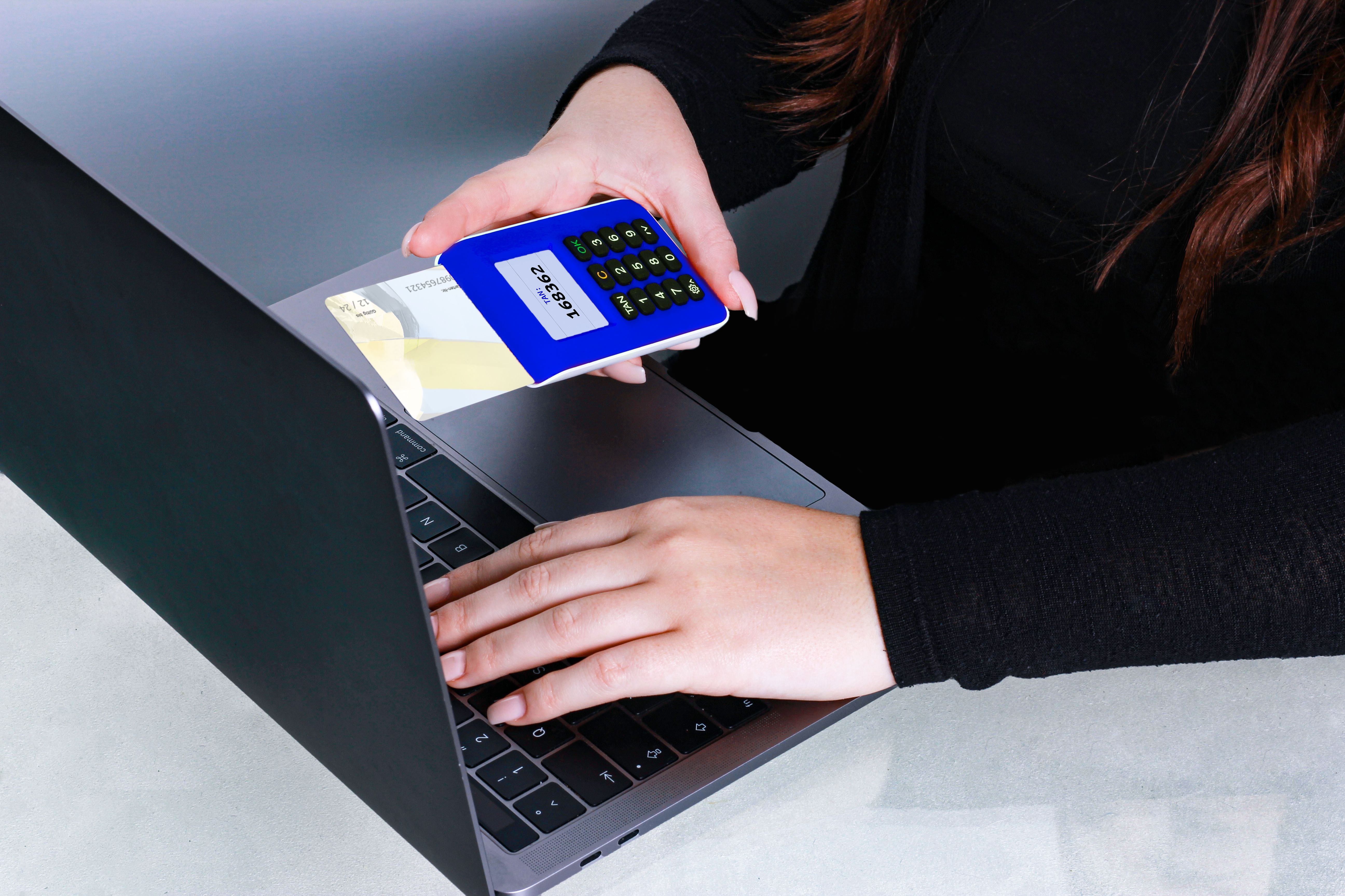 Person using a card reader beside a laptop for secure online payment, representing financial data security.