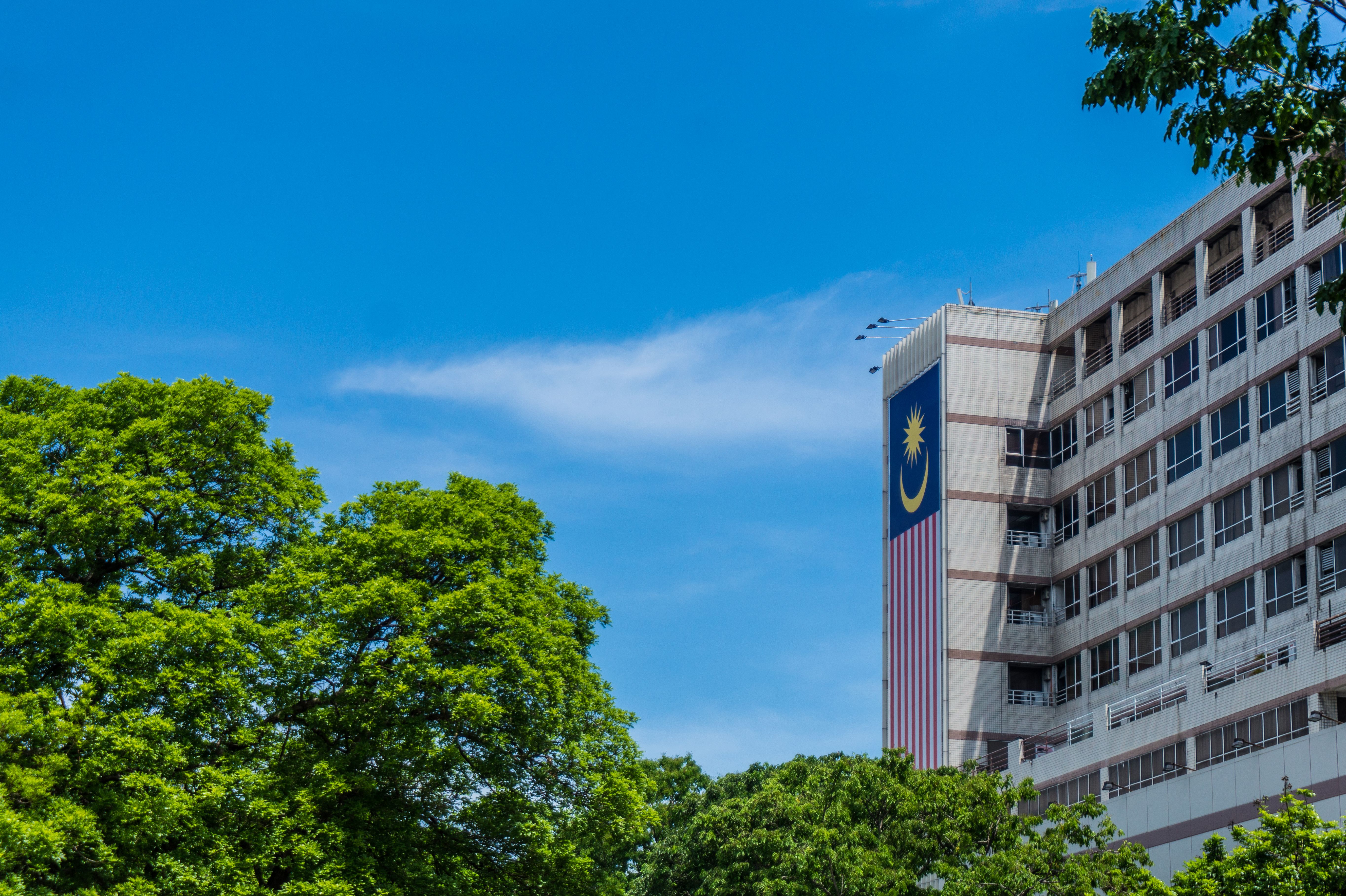 Modern building with the Malaysian flag and greenery in Kota Kinabalu, Sabah, representing public institutions and development.