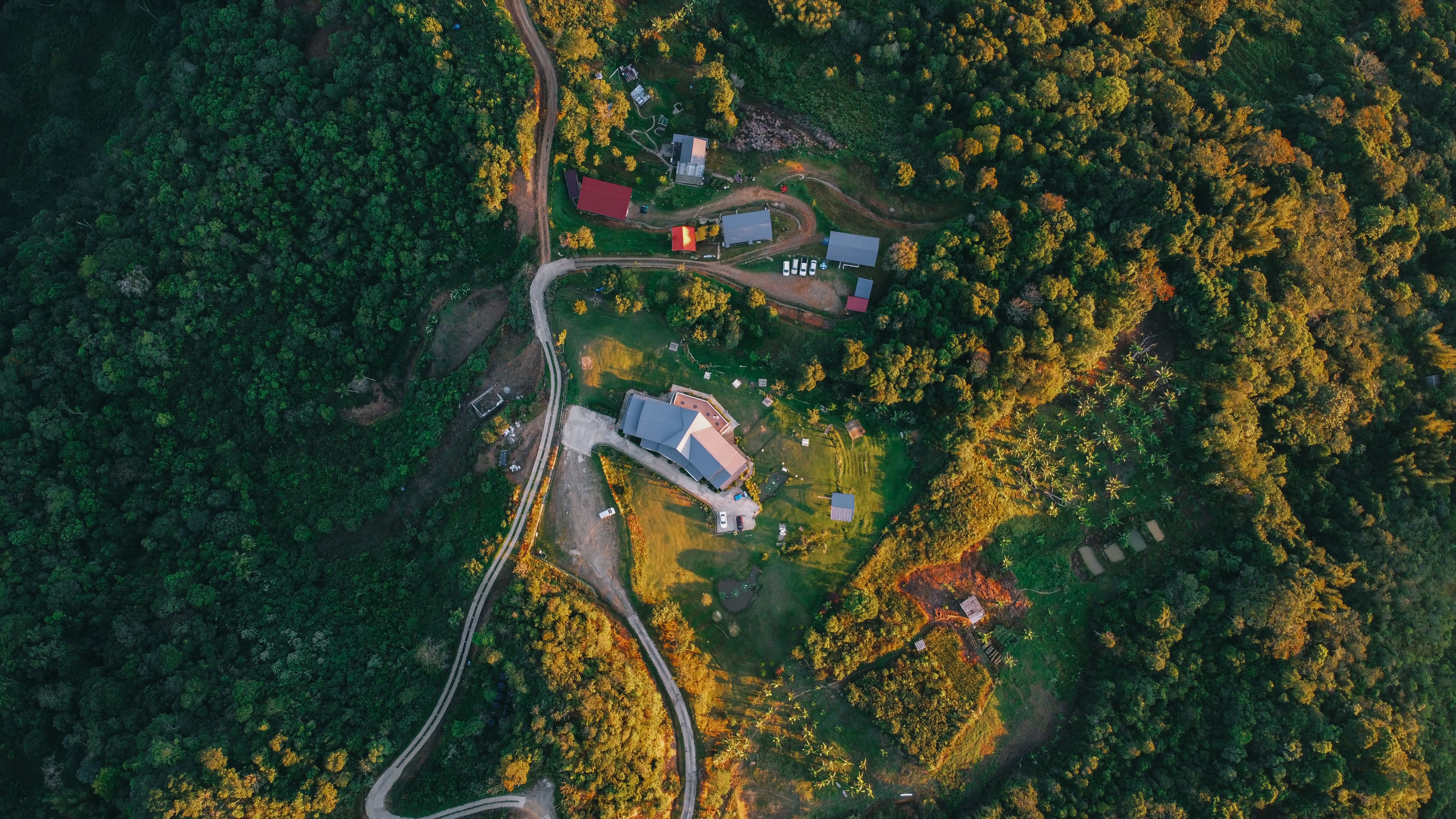 Aerial view of a rural village surrounded by green landscape in Kundasang, Sabah, Malaysia.