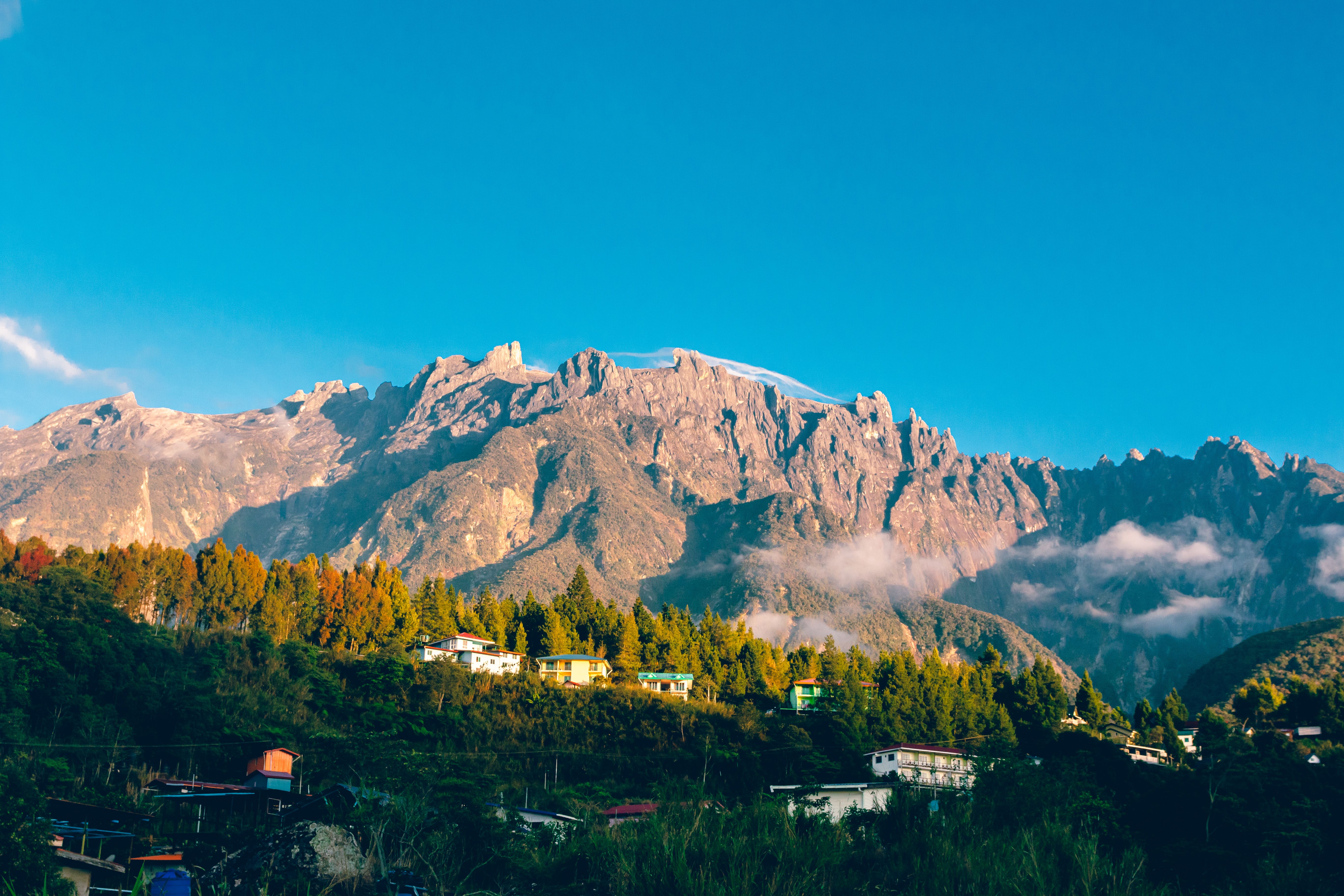 Mount Kinabalu rising above a village landscape in Sabah, Malaysia, symbolizing the region's natural and cultural identity.